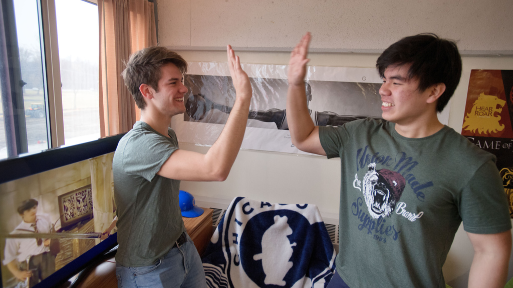 Two roommates high fiving each other